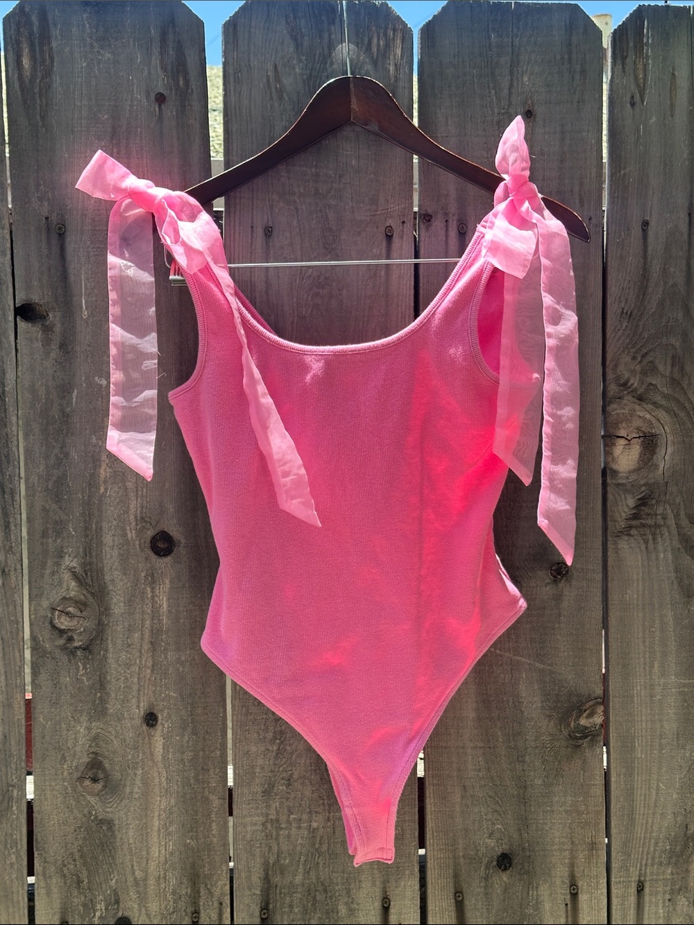 Pink with adjustable bows body suit, size M